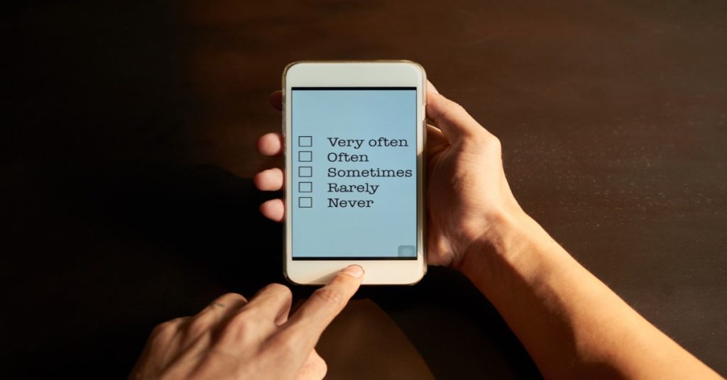 Hand holding a smartphone displaying 5 options for a survey question, representing mobile-friendly survey.
