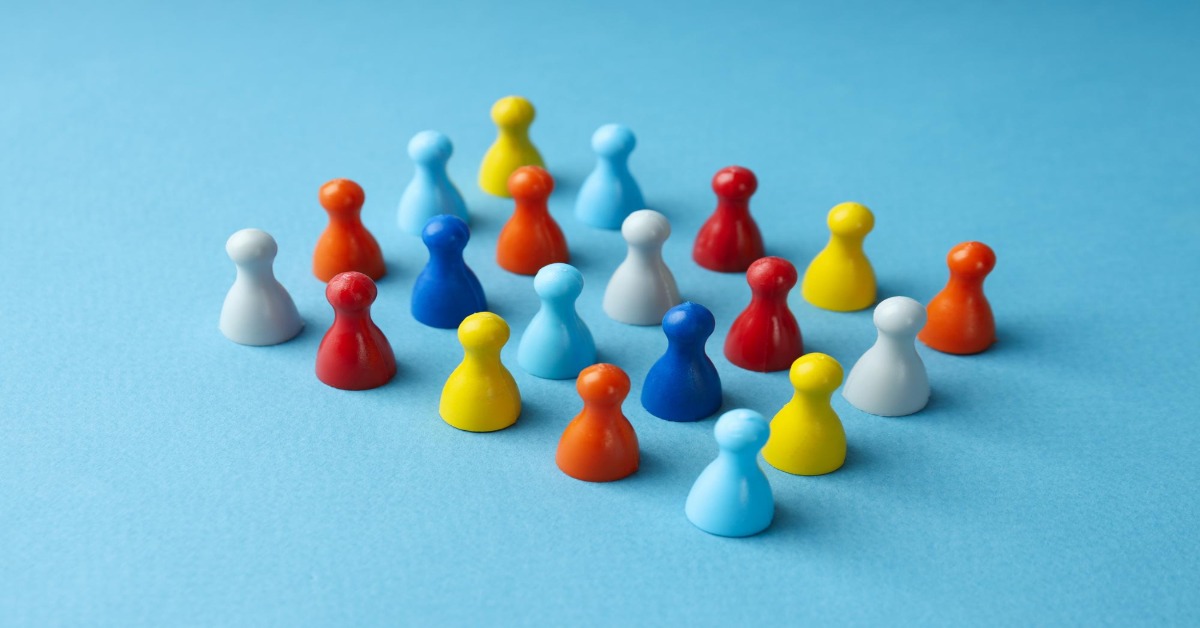 A group of colorful wooden figures on a blue background, illustrating the concept of random sampling in survey accuracy.