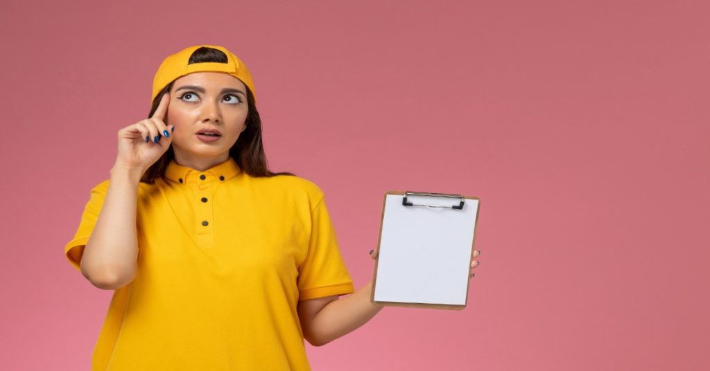 A woman in a yellow shirt holds a clipboard, discussing strategies and surveys to understand survey abandonment issues.
