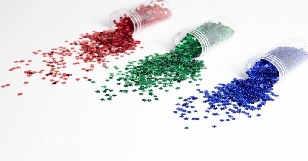 Three jars of red, green, and blue glitter, illustrating random sampling and its importance in survey accuracy.