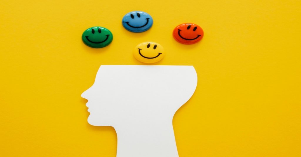 Open head with different faces, depicting different emotions.