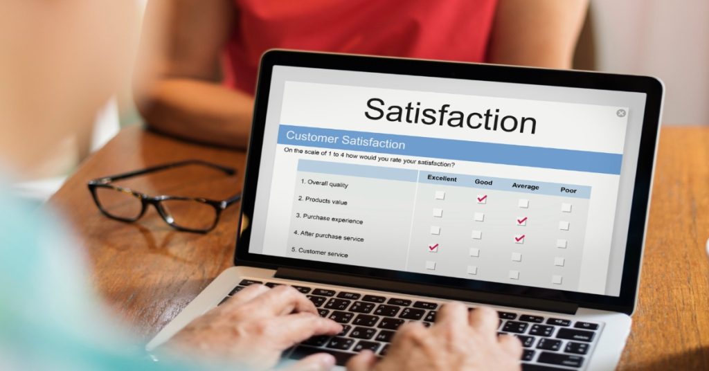 A laptop showing customer satisfaction survey with questions.