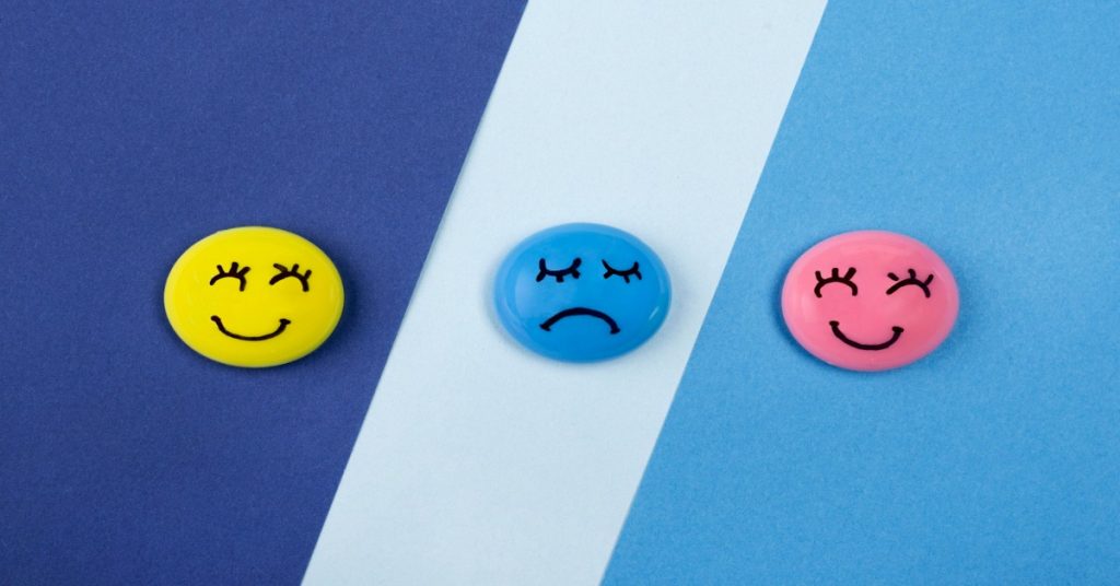 Three colorful buttons featuring emotions, representing customer review analysis and aspect-based sentiment evaluation.