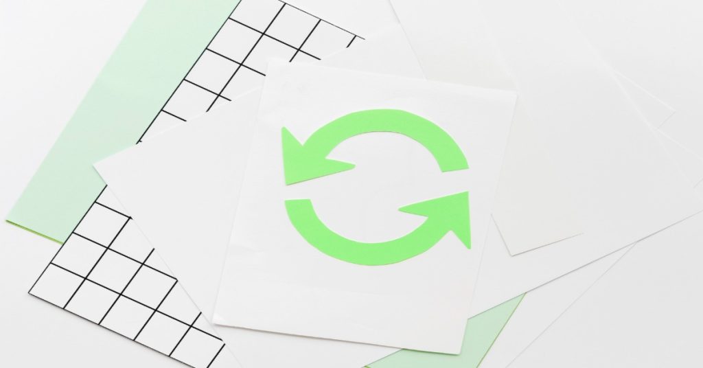 Image of paper with a green arrow symbol, illustrating the experience of feedback loops to enhance action.